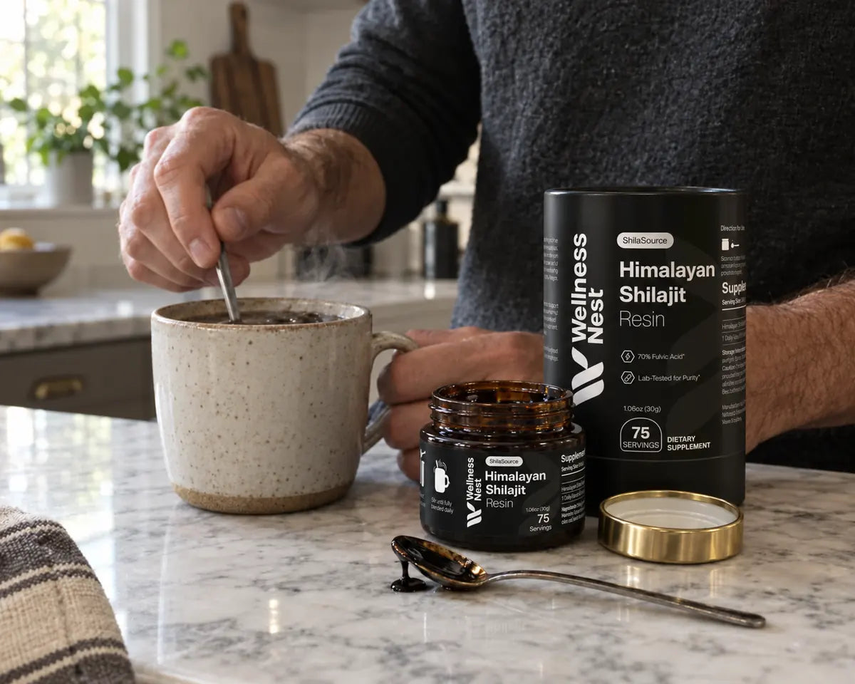 Hands stirring a pea-sized piece of resin into a mug, with the ShilaSource jar and spoon on marble