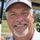 Candid portrait of Bob, 61, wearing a golf polo and cap on a sunny Saturday morning golf course