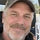 Candid portrait of Jim, 52, a general contractor in a canvas jacket standing beside his pickup truck on a Monday morning with